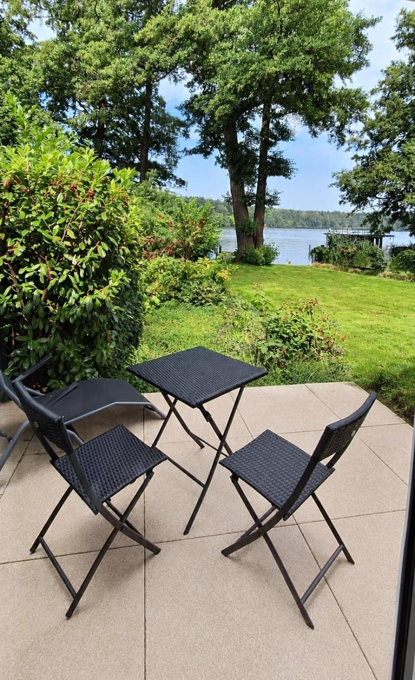 Kleine Terrasse des Gästehauses mit Bistrotisch und Stühlen, Blick durch Bäume auf den Großen Zug