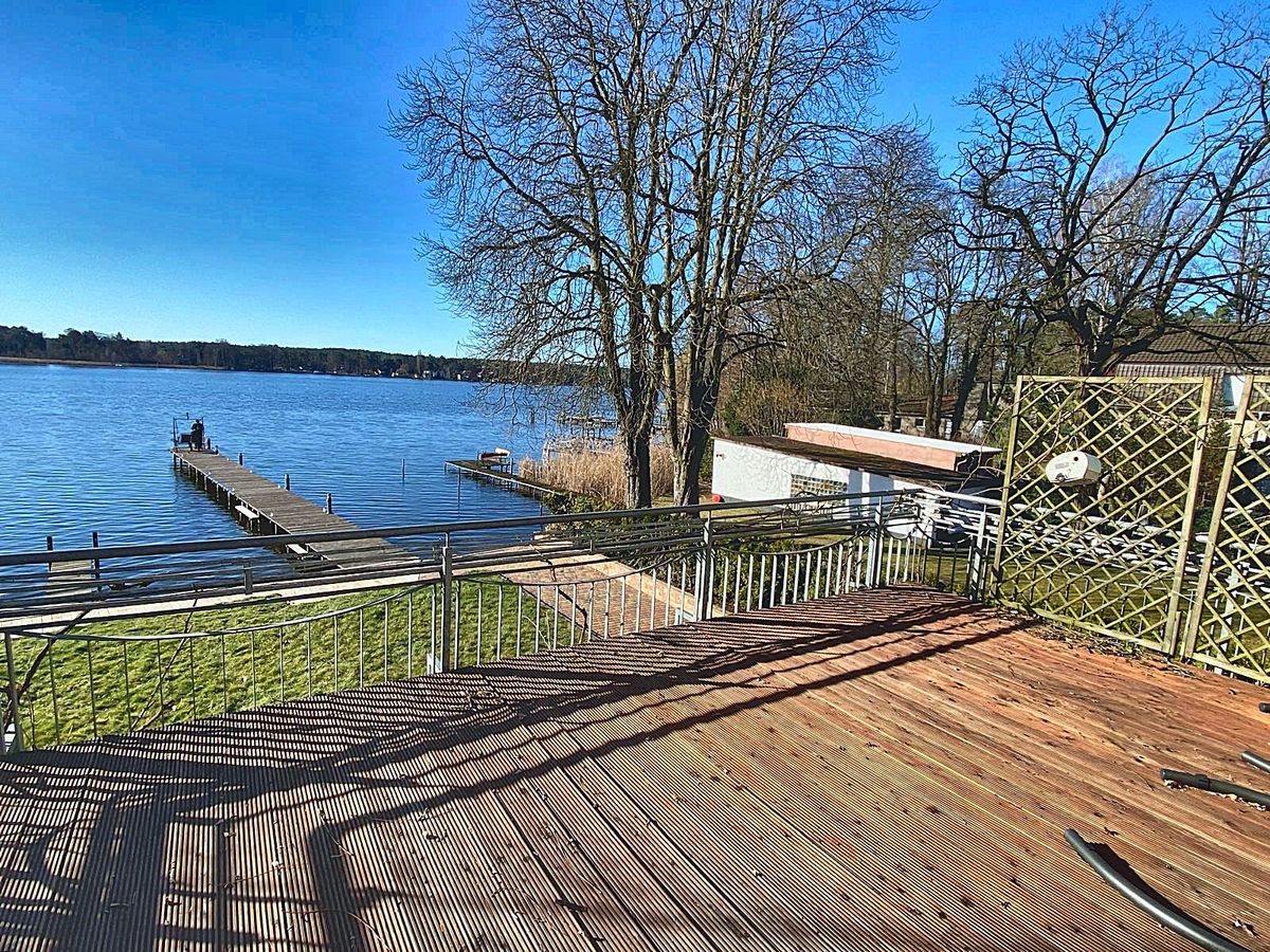 Holzterrasse am Wasser mit Blick auf Steg und Krüpelsee