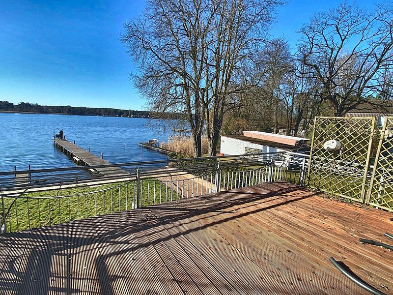 Holzterrasse am Wasser mit Blick auf Steg und Krüpelsee