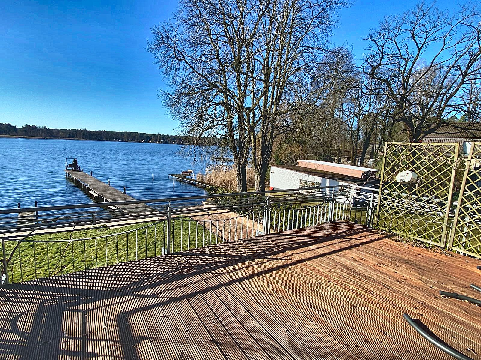 Holzterrasse am Wasser mit Blick auf Steg und Krüpelsee