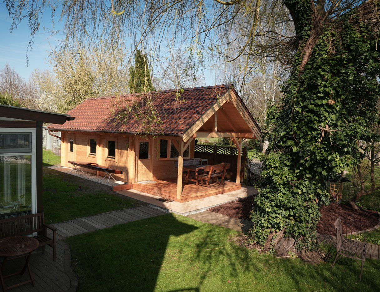 Überdachter Holzpavillon im Garten der Villa am Krüpelsee