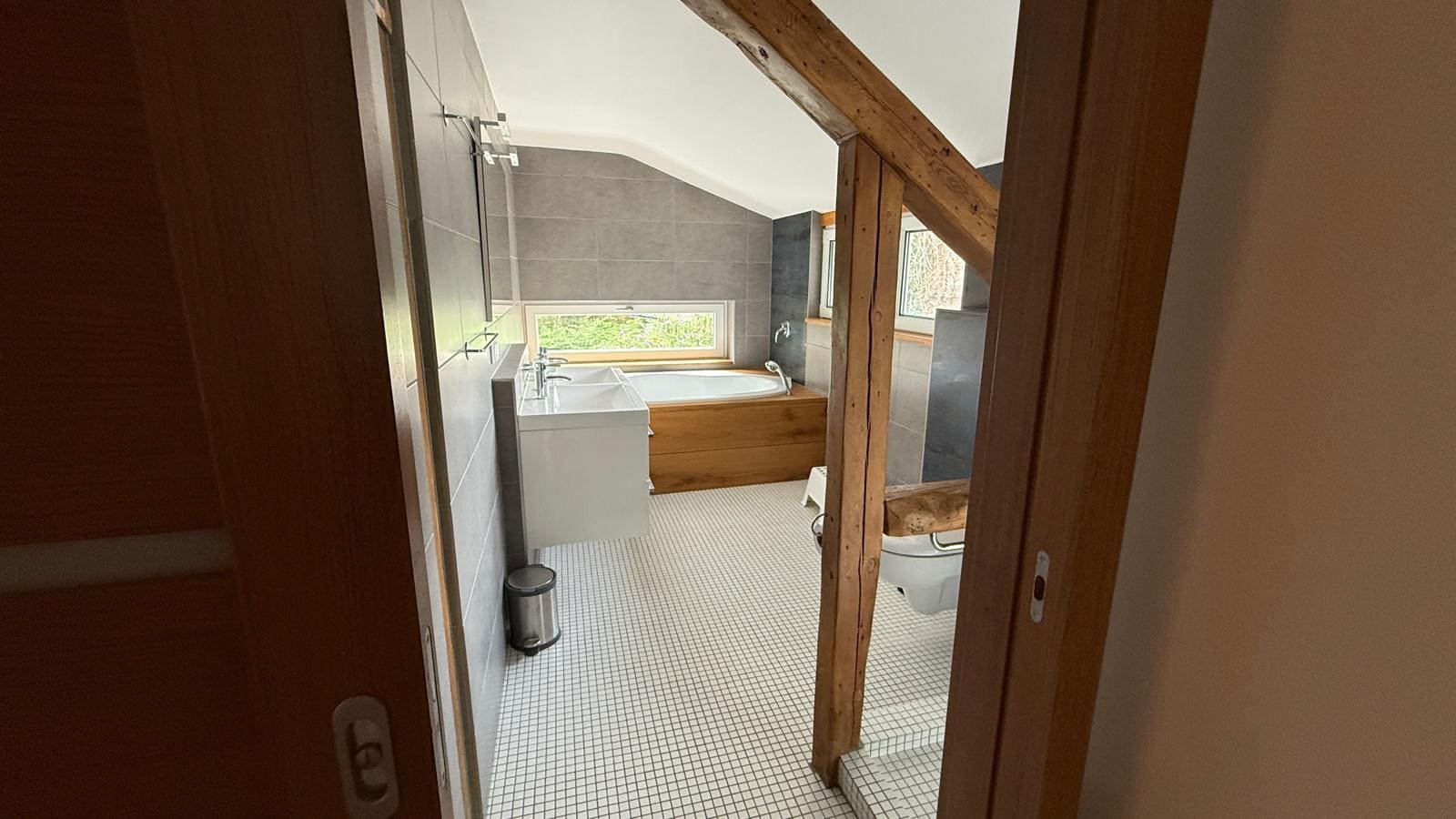 Bad mit Waschtisch, Badewanne und Holzbalken